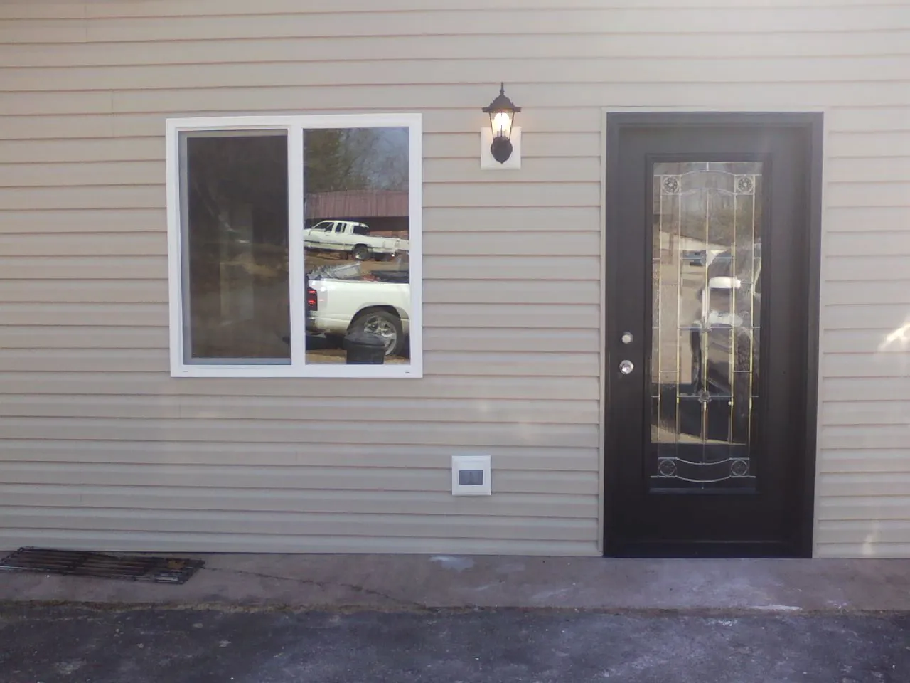 New siding, window and entry door on the side of an addition in Randolph